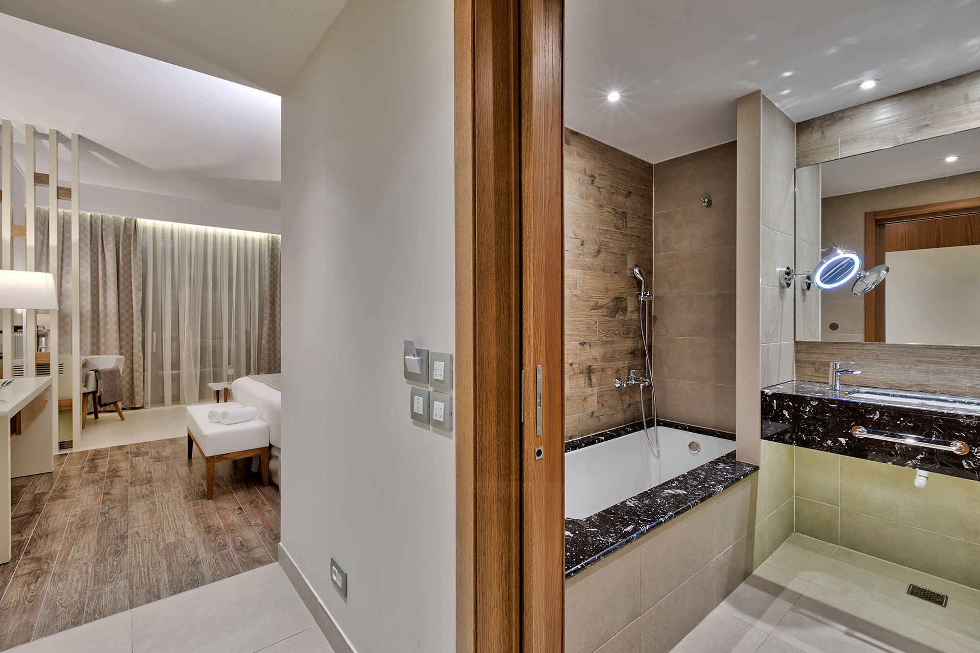 Family room with elegant ensuite bathroom featuring marble sink and bathtub, plus cozy bedroom area