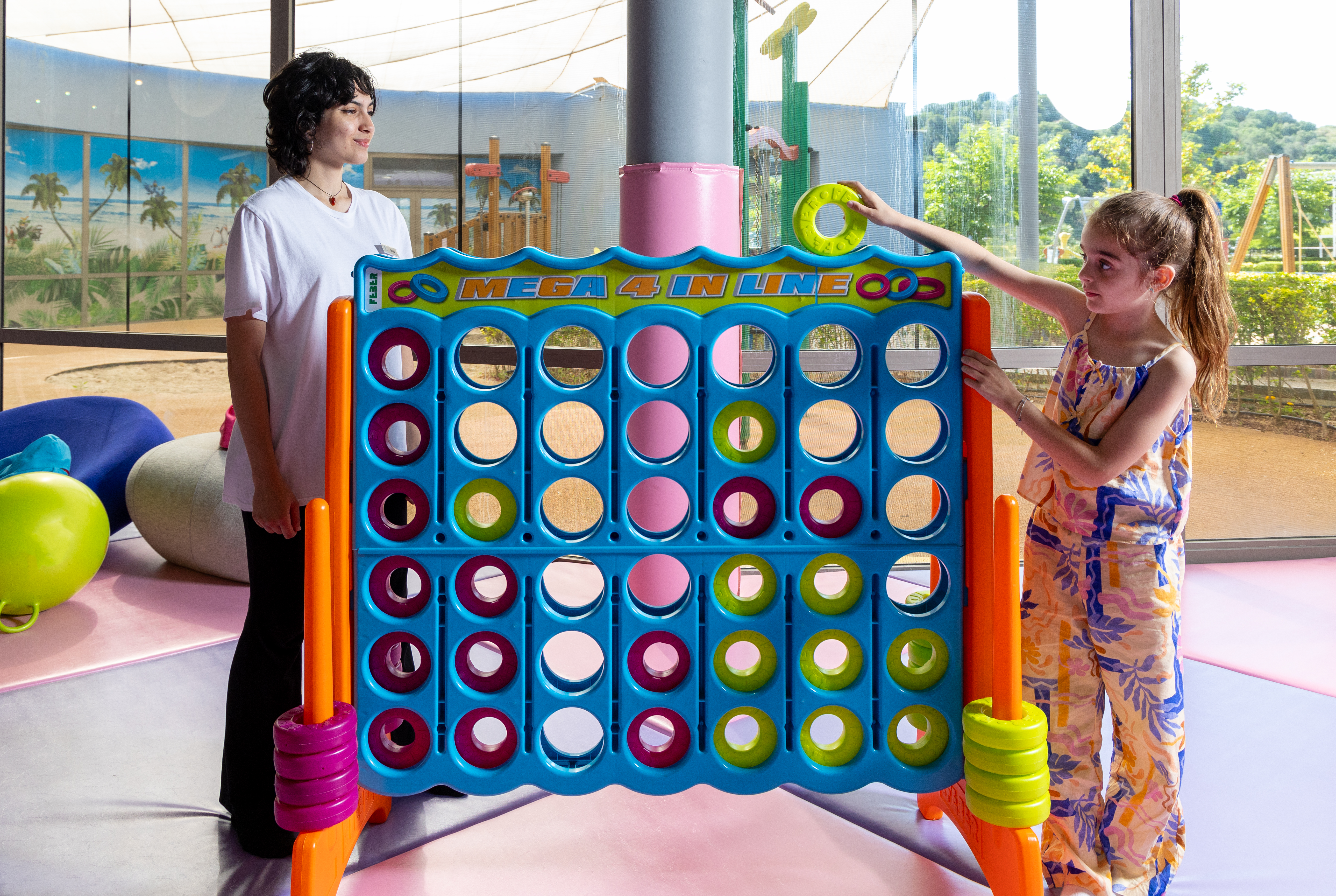 Girl play a giant Connect Four game under staff supervision at Kids Planet