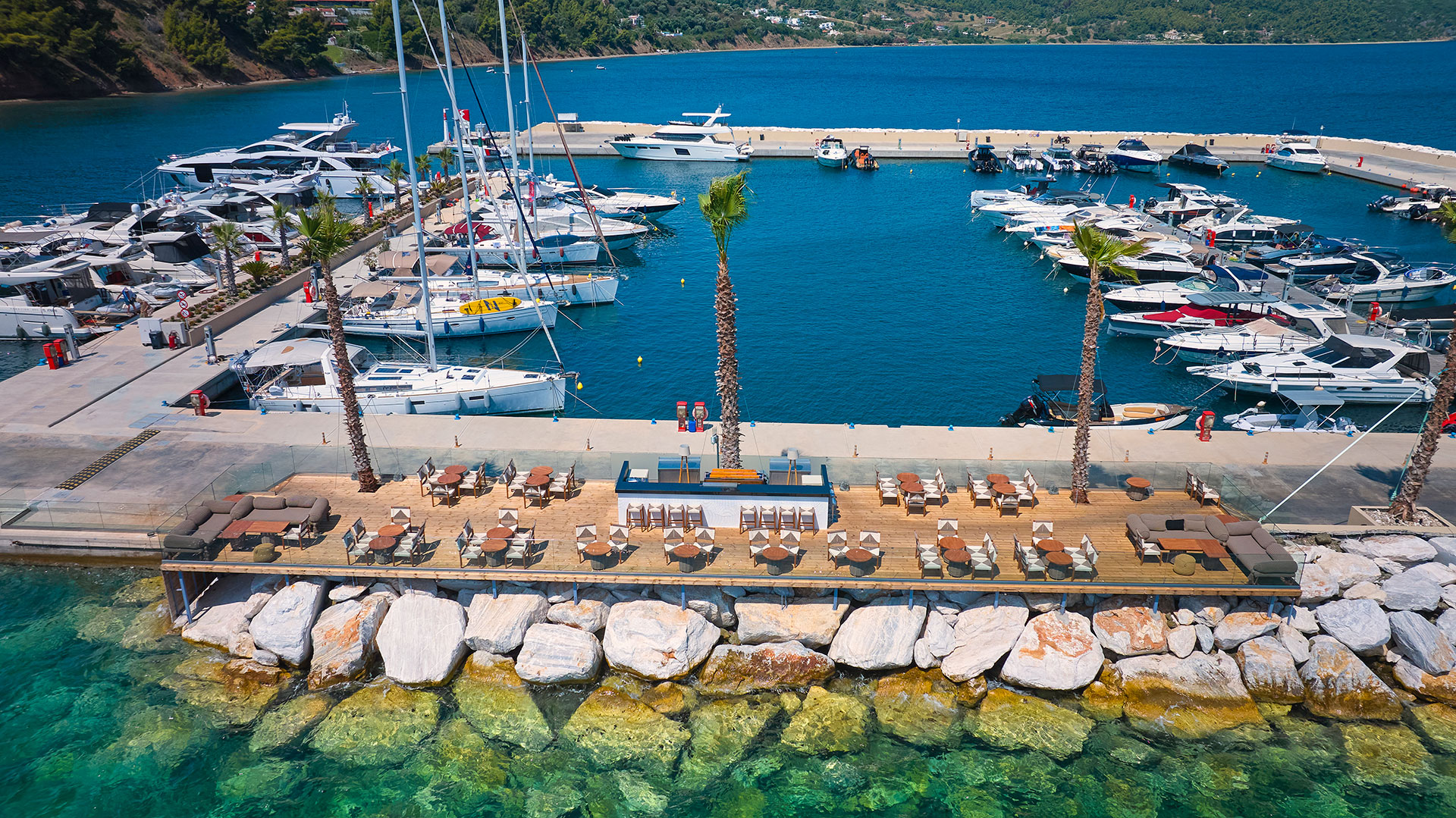 Aerial view of Mirage On The Rocks bar with dockside seating and marina backdrop