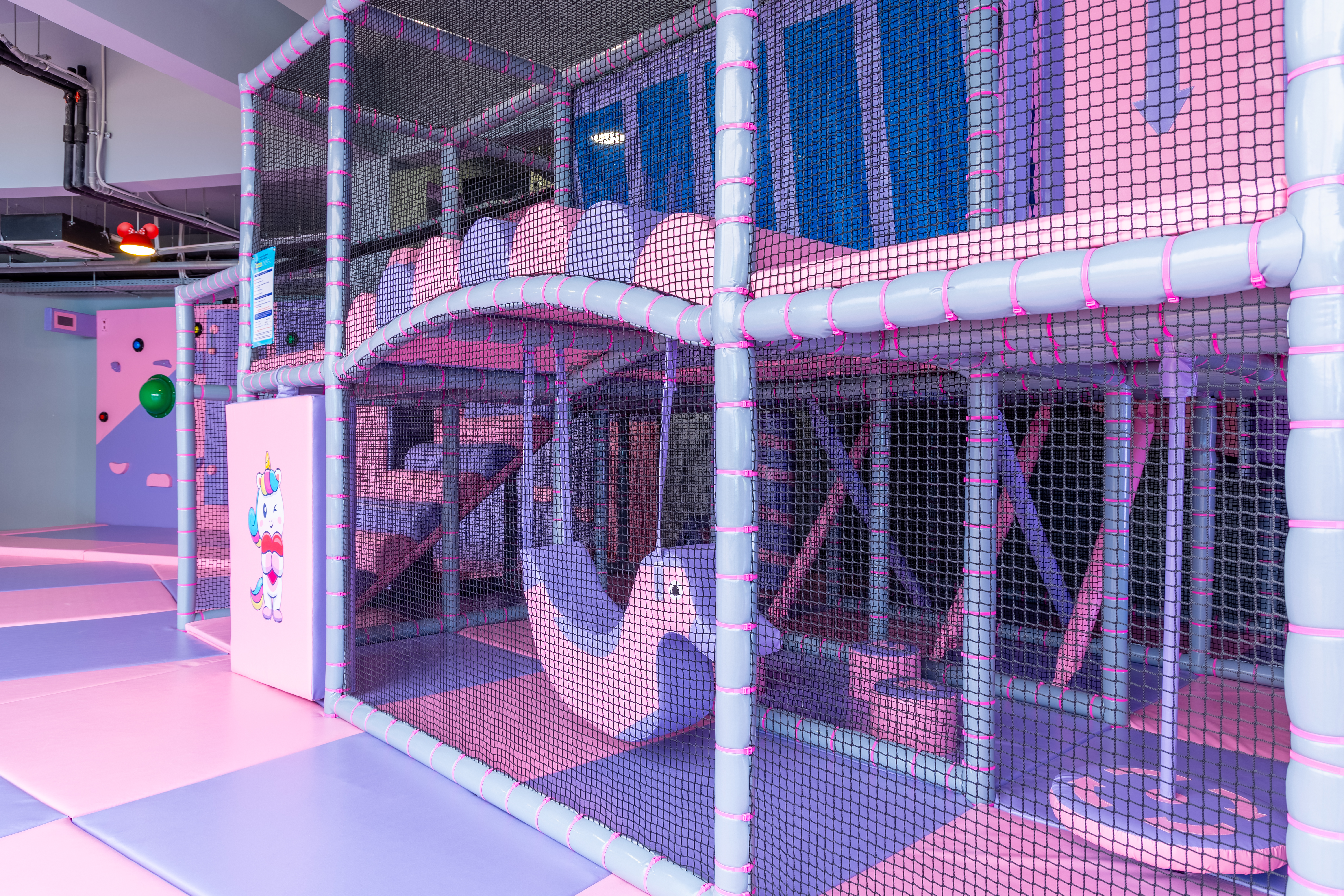 Colorful indoor play area with climbing nets and soft swings at Kids Planet