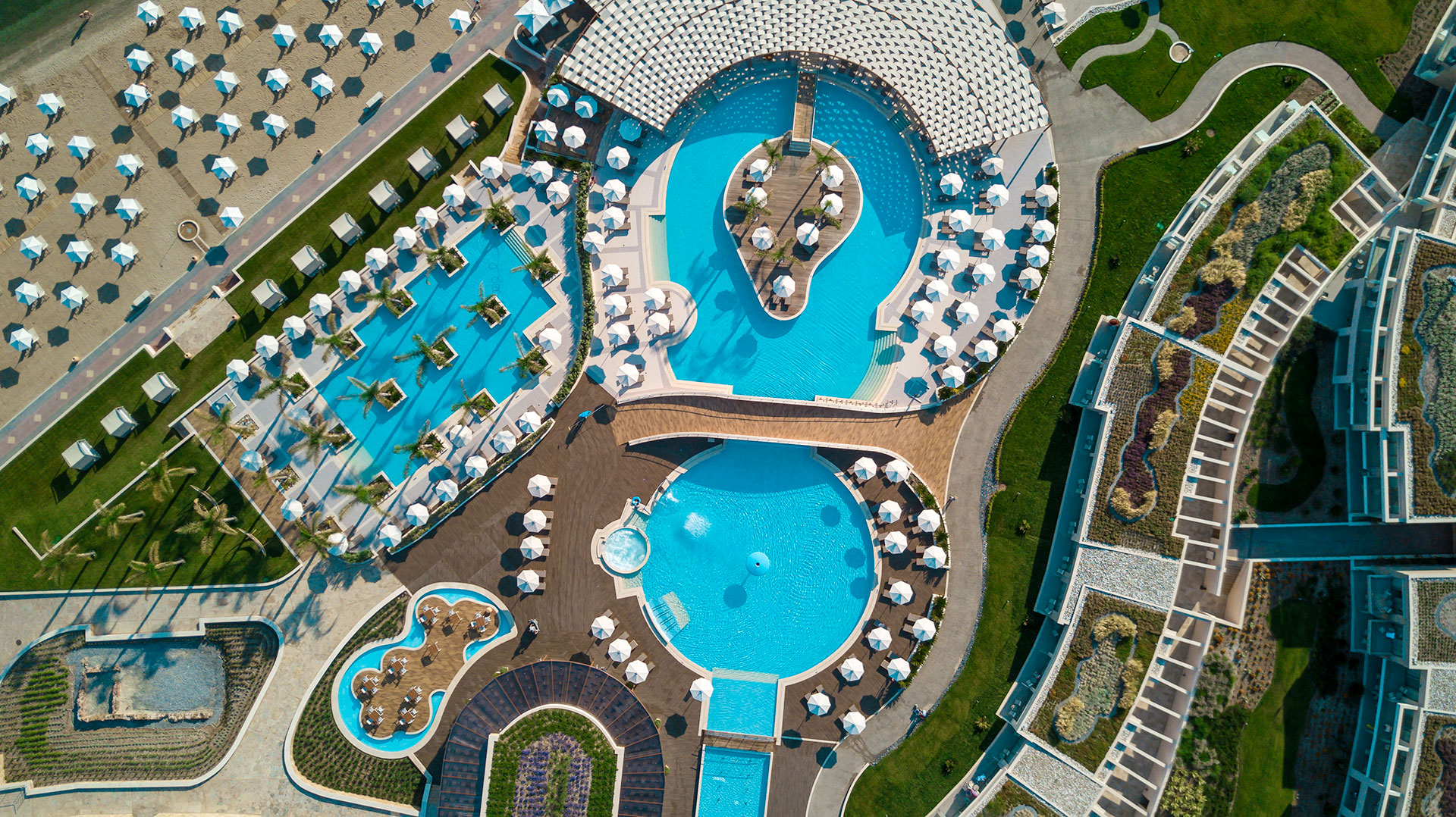 Aerial panoramic view of luxury pools, gardens and beachfront layout