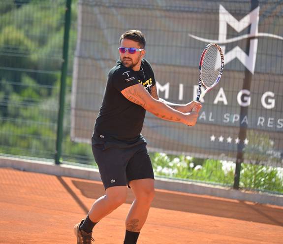 Man playing tennis in Miraggio tennis court