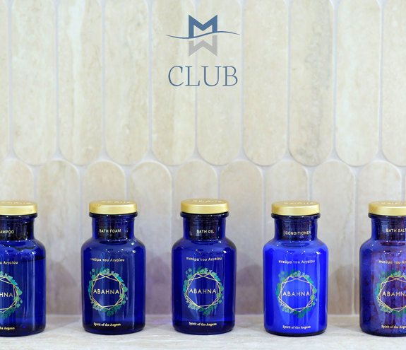 Close up to bathroom amenities in blue designer vases against a modern detailed wall