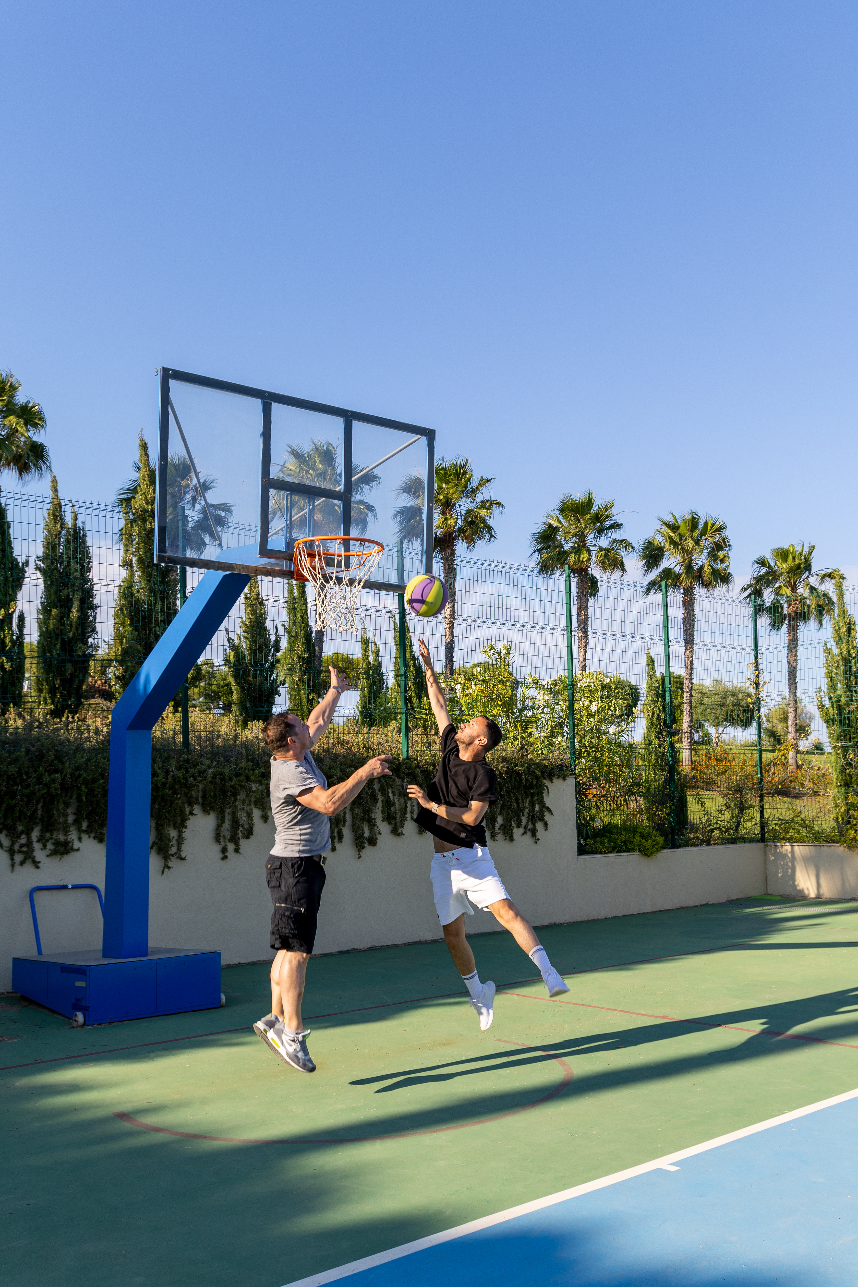 Two basketball players jumping mid-air, one shooting and one blocking the ball