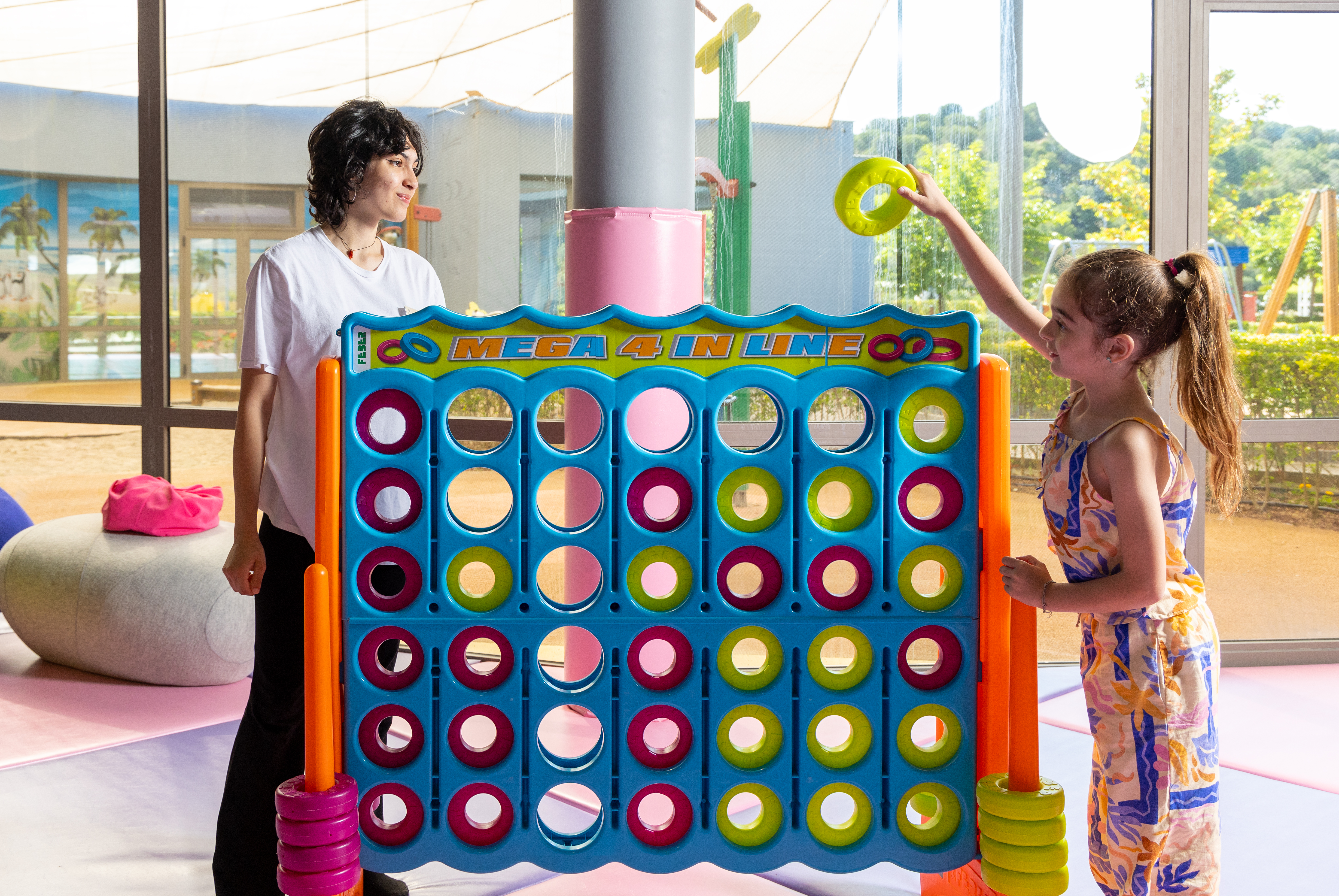 Girl having fun playing a giant Connect Four game at the indoor Kids Planet