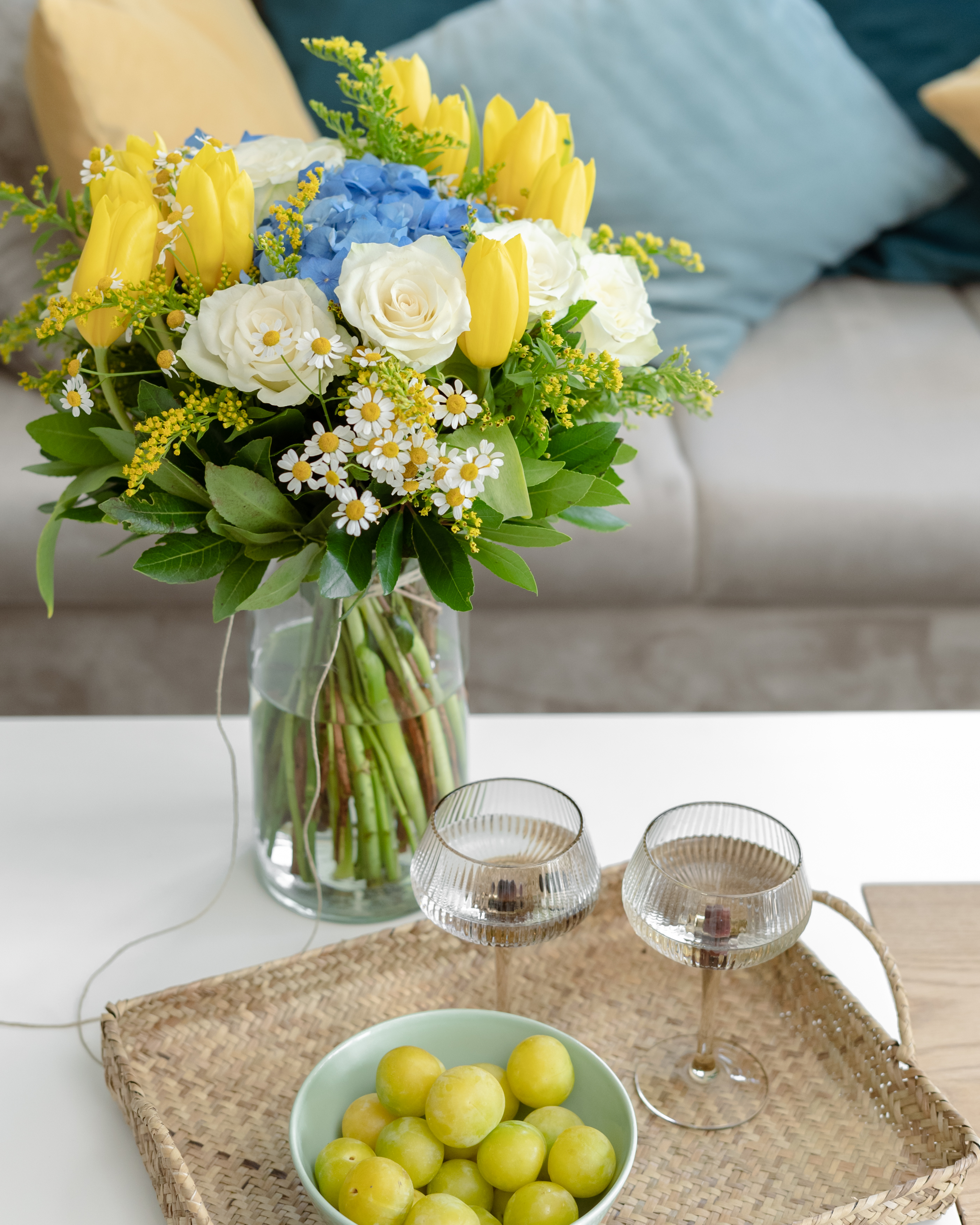 Small glass vase with delicate white and yellow flowers on display