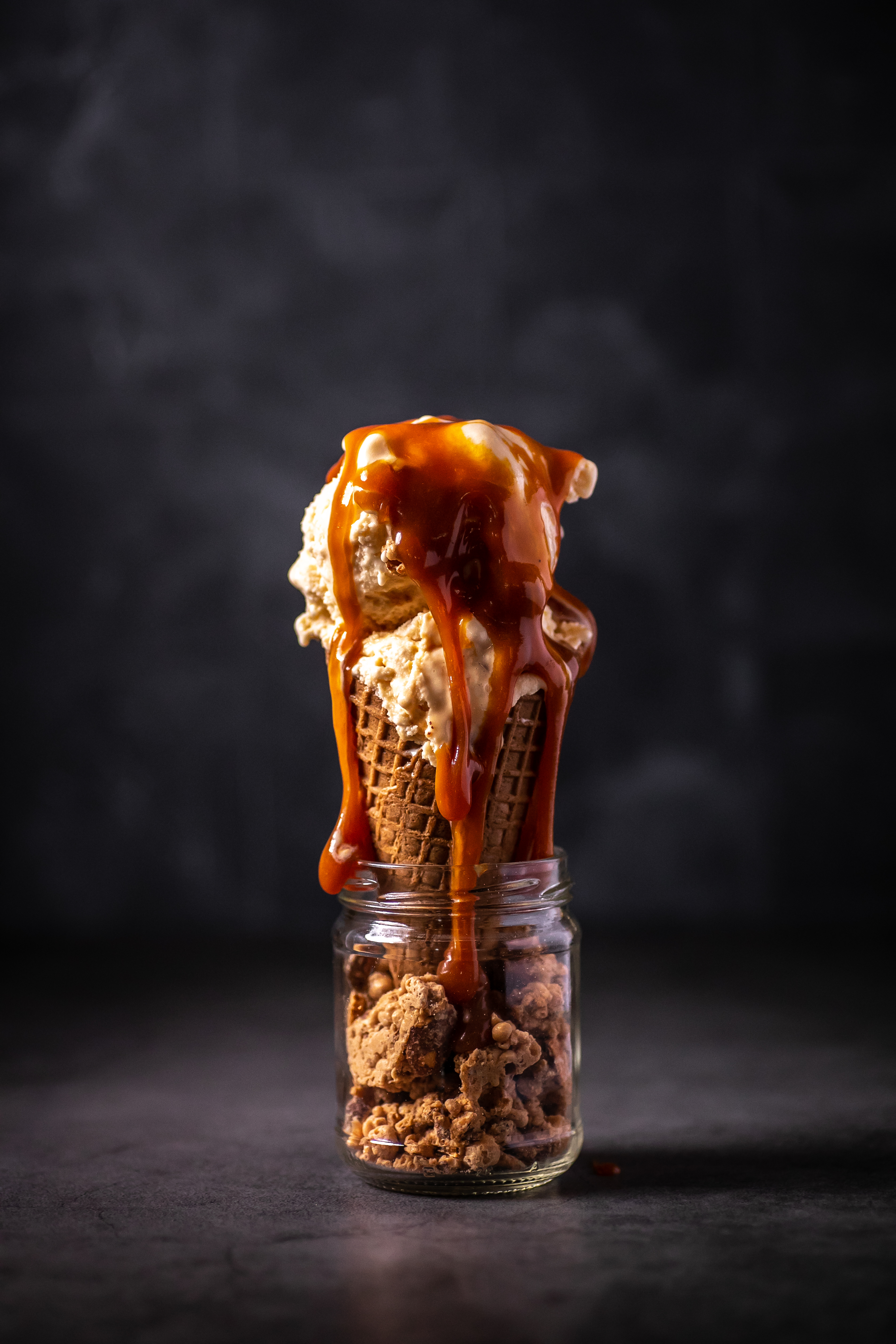 Fregio caramel ice cream cone dripping with rich sauce over crunchy cookie base