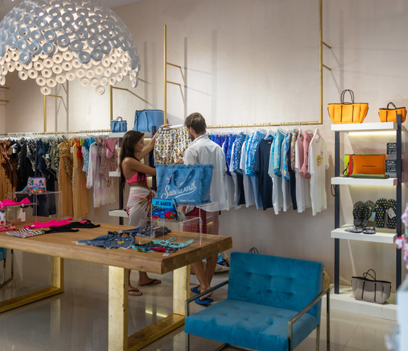 Modern boutique with stylish clothes, bags, and customers shopping inside