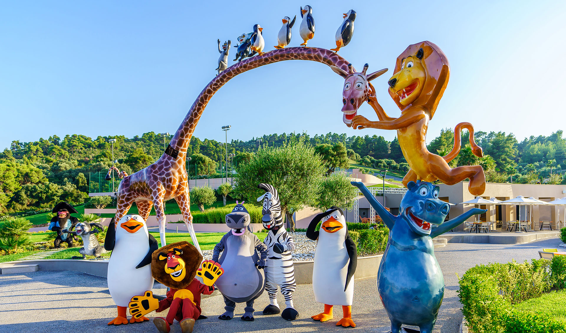 Performers dressed as Madagascar characters in front of the Entrance of Kids Planet with Madagascar character's statues