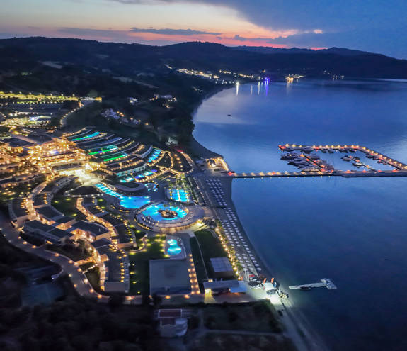 Side view of the resort, the marina and the sea at night time