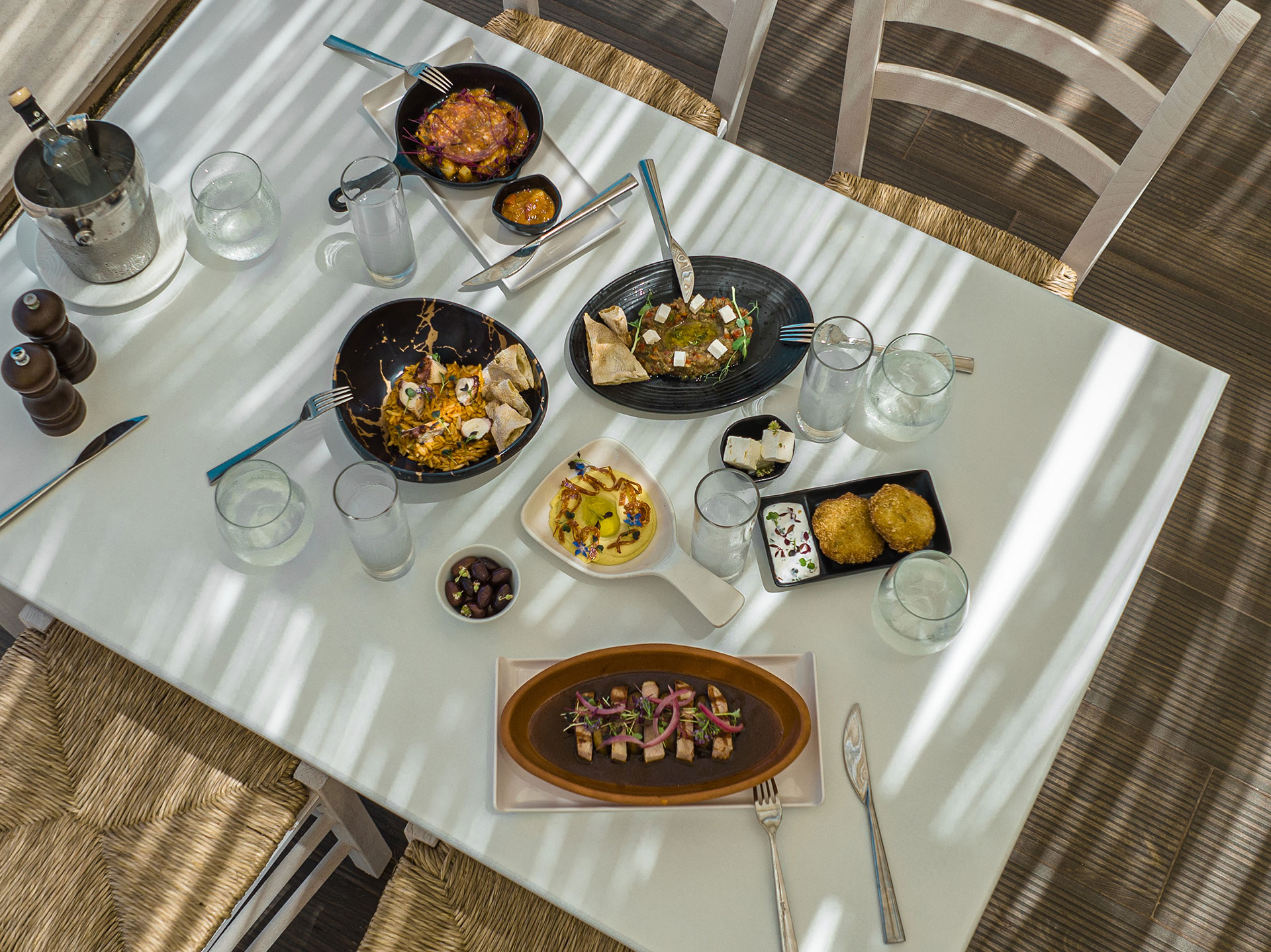 Top down of a served table in Mezedaki beach restaurant featuring ouzo and Greek meze dishes