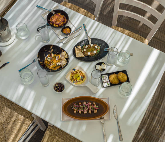 Mezedaki Beach Restaurant table with a variety of dishes