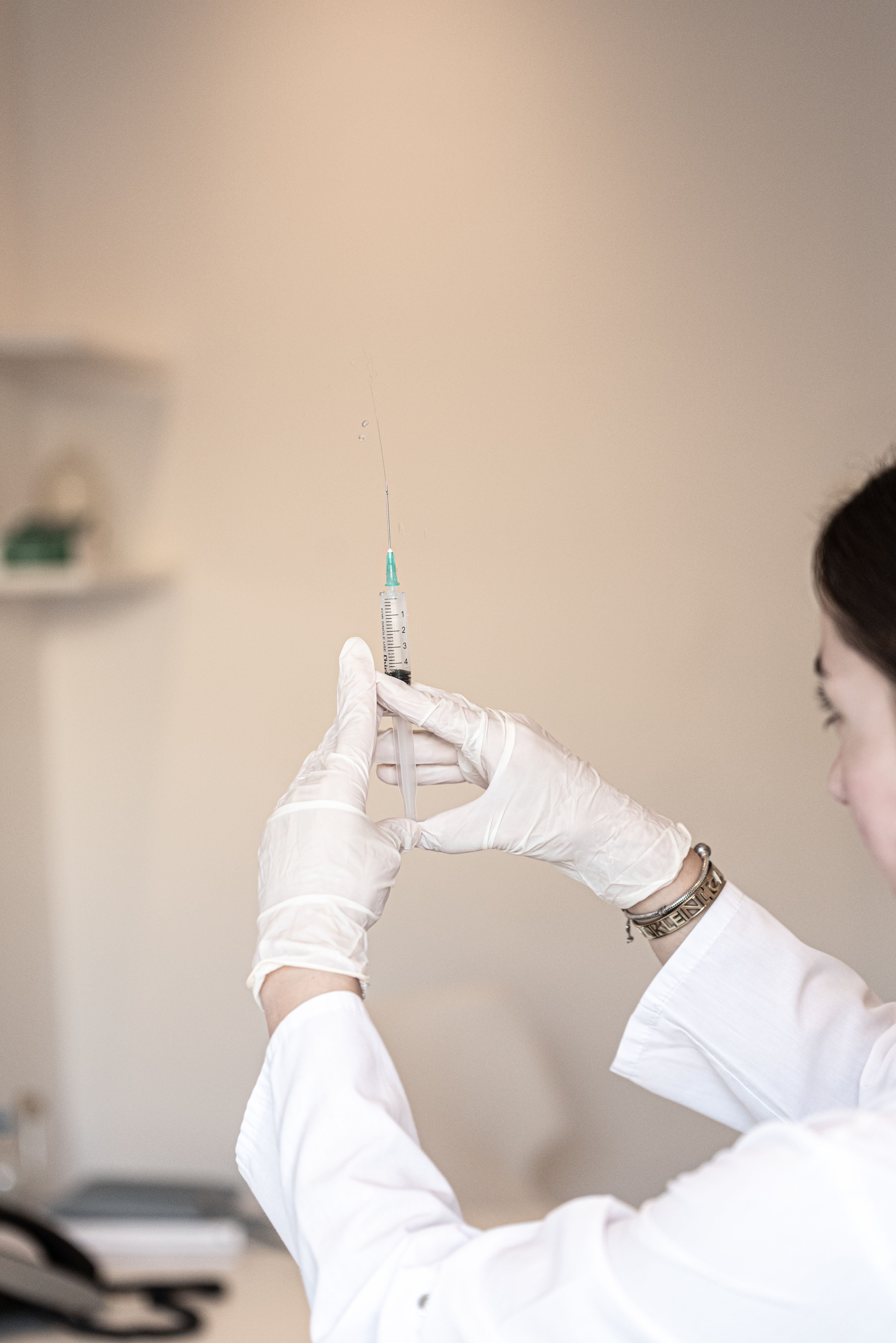 Healthcare professional preparing a syringe inside the medical center