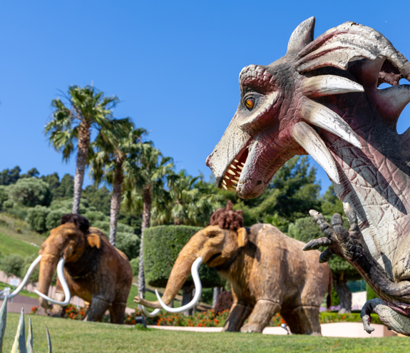 Dinosaur and mammoth sculptures at the outdoor themed area near Kids Planet