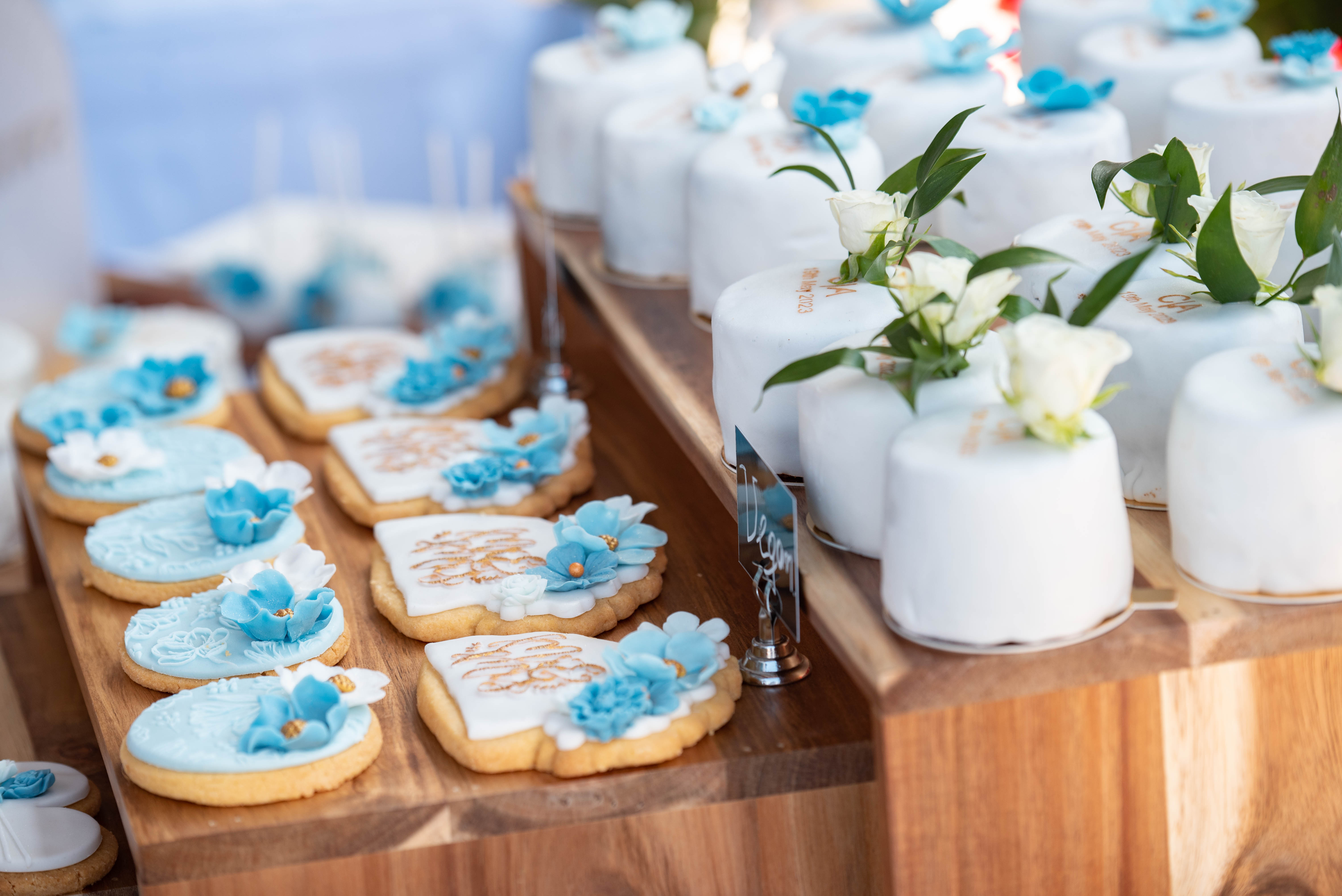 Elegant wedding desserts with white fondant and blue floral decorations
