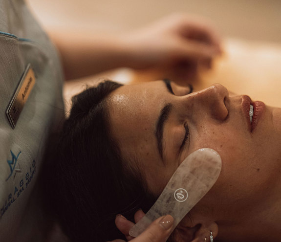 Facial treatment with stone massage tool for relaxation and glow