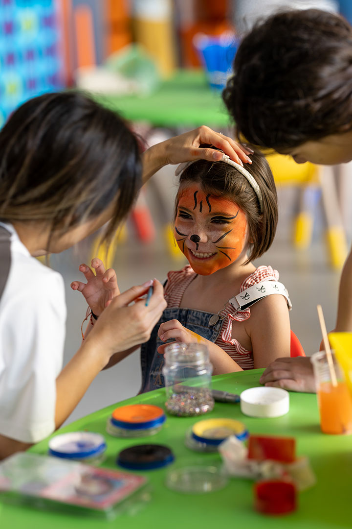 Entertainer painting kids faces with animal patterns in the Kids Planet play area