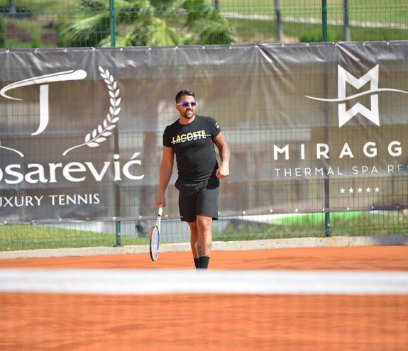 Man playing tennis in Miraggio tennis court