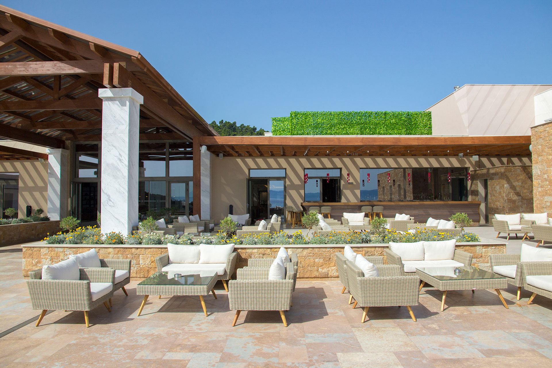 Outdoor Lobby bar seating area and entrance featuring columns supporting a wooden pergola
