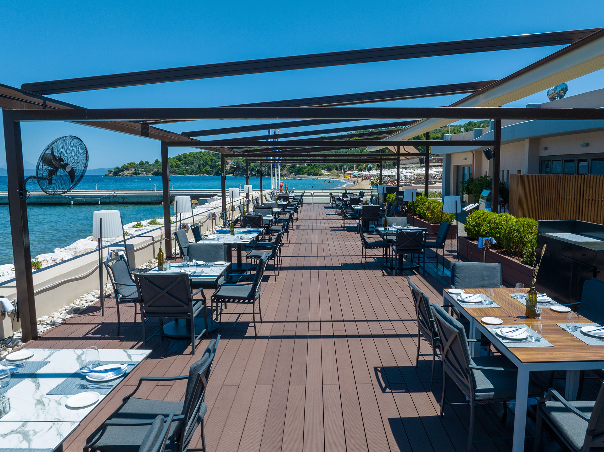 Toroneo restaurant's modern waterfront dining terrace with elegant setup and sea views
