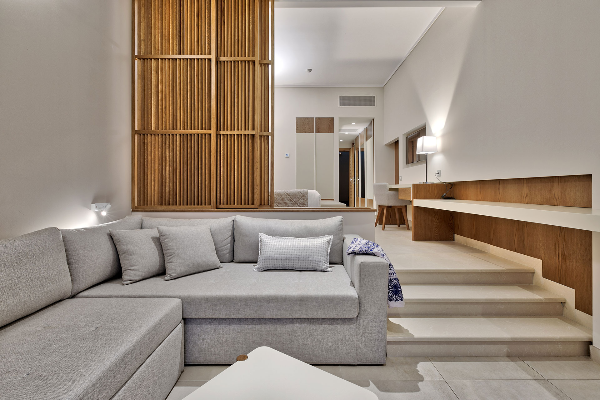 Cozy family room with split level layout, large sofa area, and warm wooden details