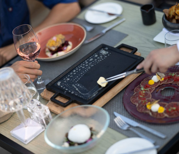 Tableside cooking experience with gourmet beef carpaccio and rose wine at Sommelier's 8 restaurant
