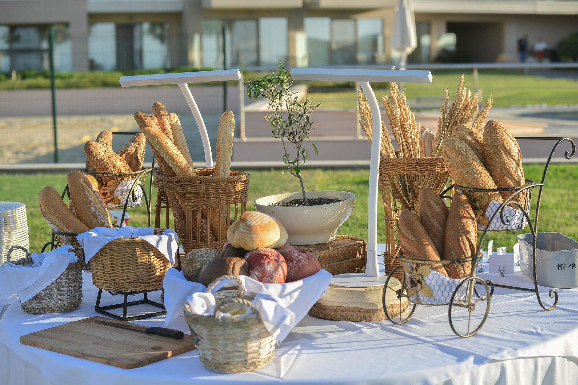 Outdoor wedding bread buffet with baskets of assorted loaves and baguettes