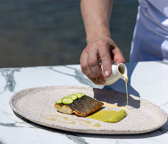 Toroneo Restaurant salmon gourmet dish being decorated by the chef