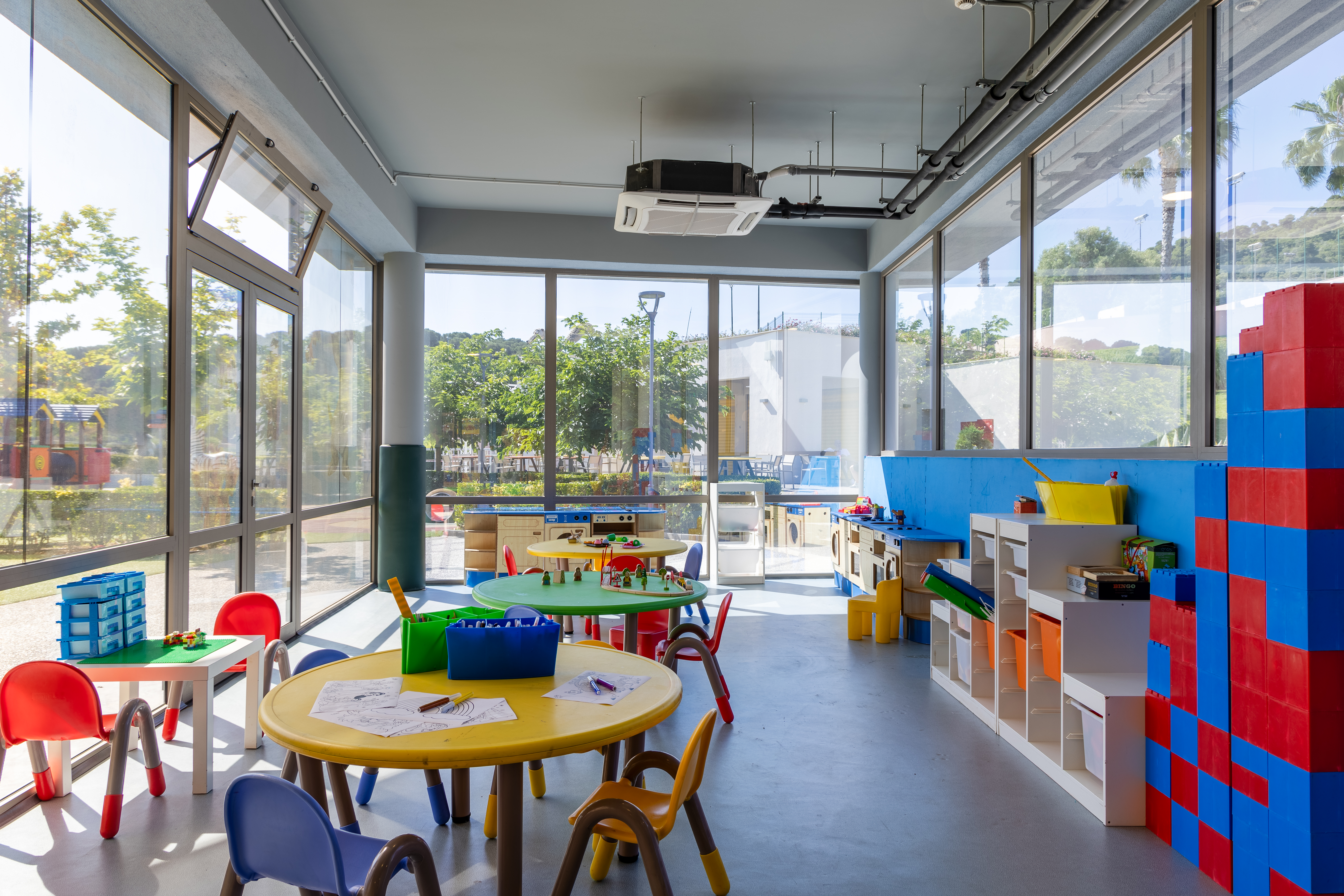 Creative indoor play area with colorful tables, chairs, and toys at Kids Planet