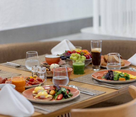 Elegant breakfast setup with omelets, Eggs Benedict, fruits, and fresh juices on a cozy table