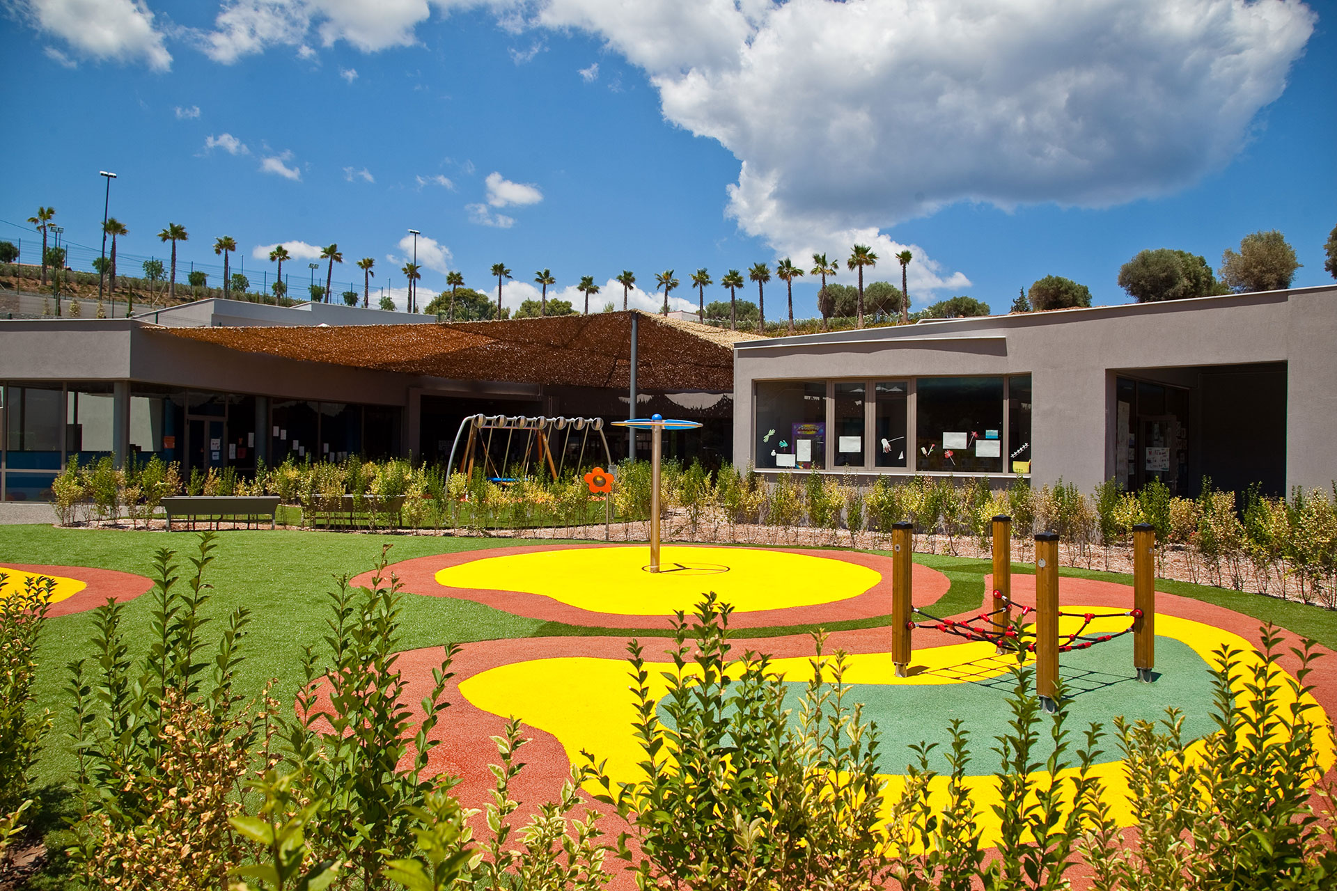 Kids Planet playground surrounded by lush greenery under clear blue skies