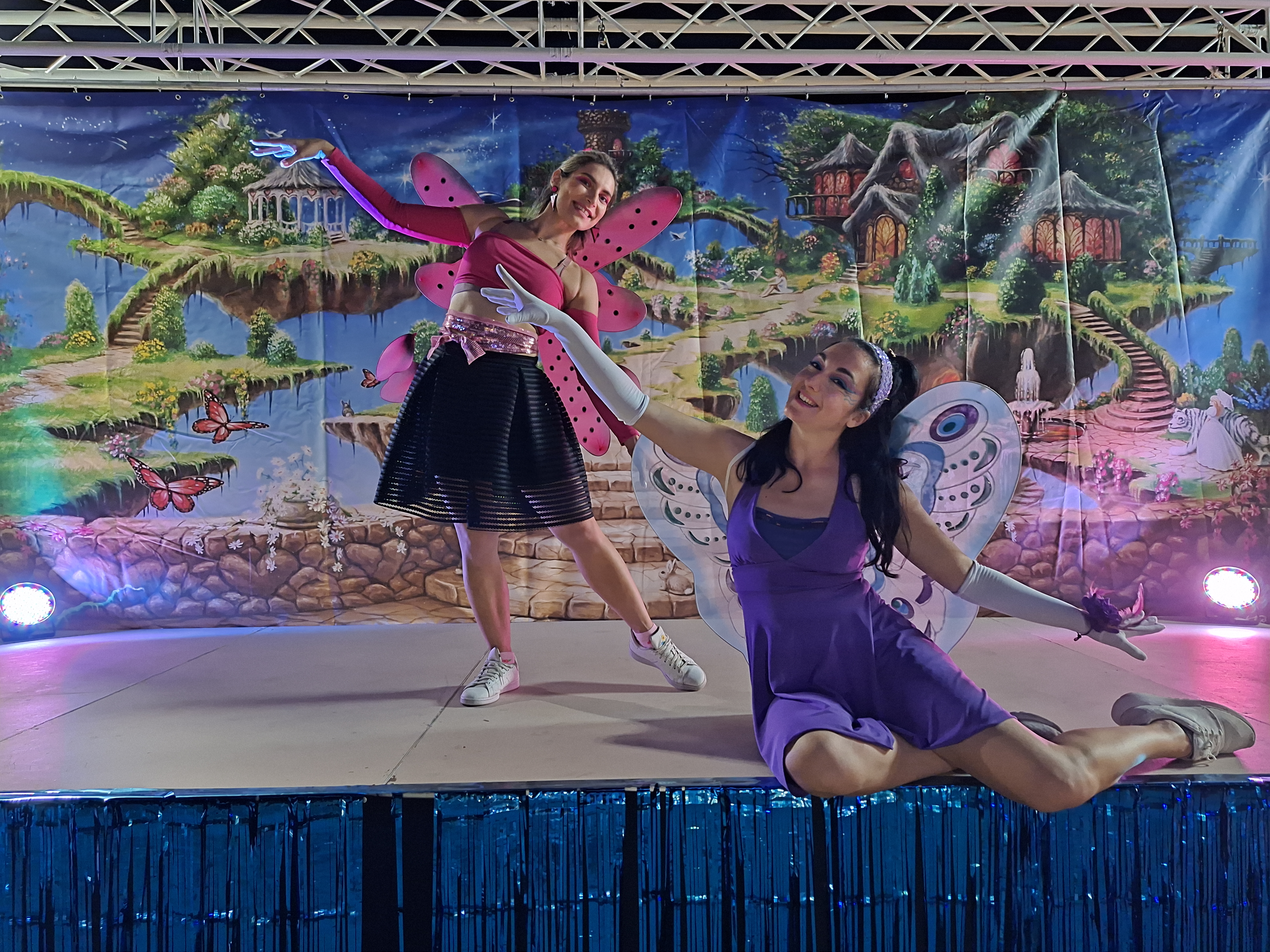 Two fairy performers dancing on a magical forest-themed stage