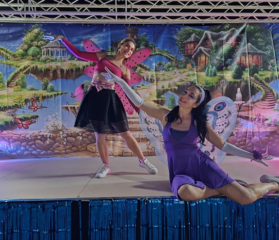 Two fairy performers dancing on a magical forest-themed stage