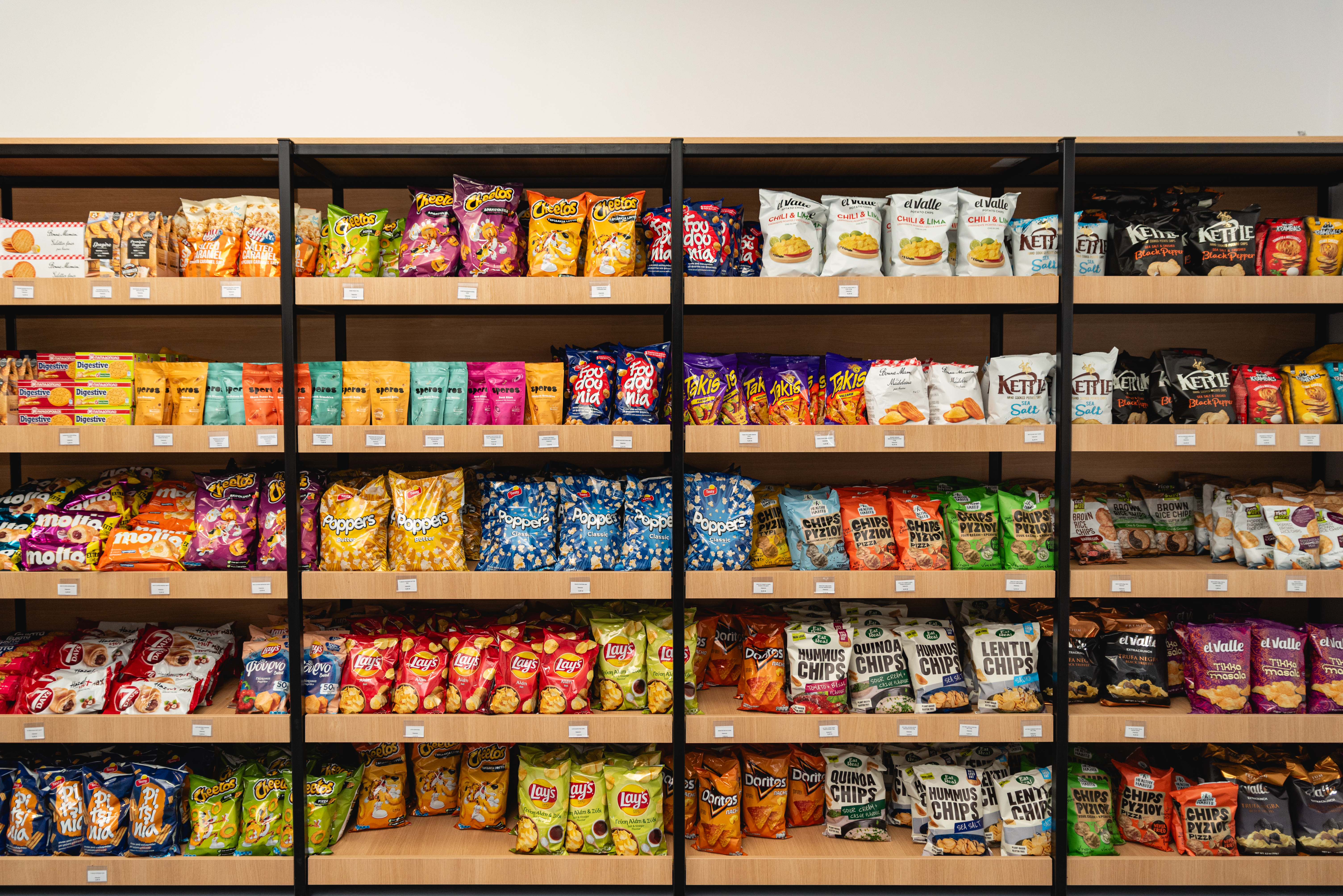 Colorful assortment of chips and snacks neatly organized on wooden shelves