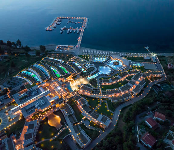 Top-down view of the resort, the sea and the marina at night time