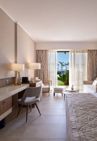 Deluxe Pool Front Room bed, sofa, chairs and amenities