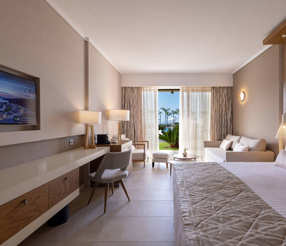 Deluxe Pool Front Room bed, sofa, chairs and amenities