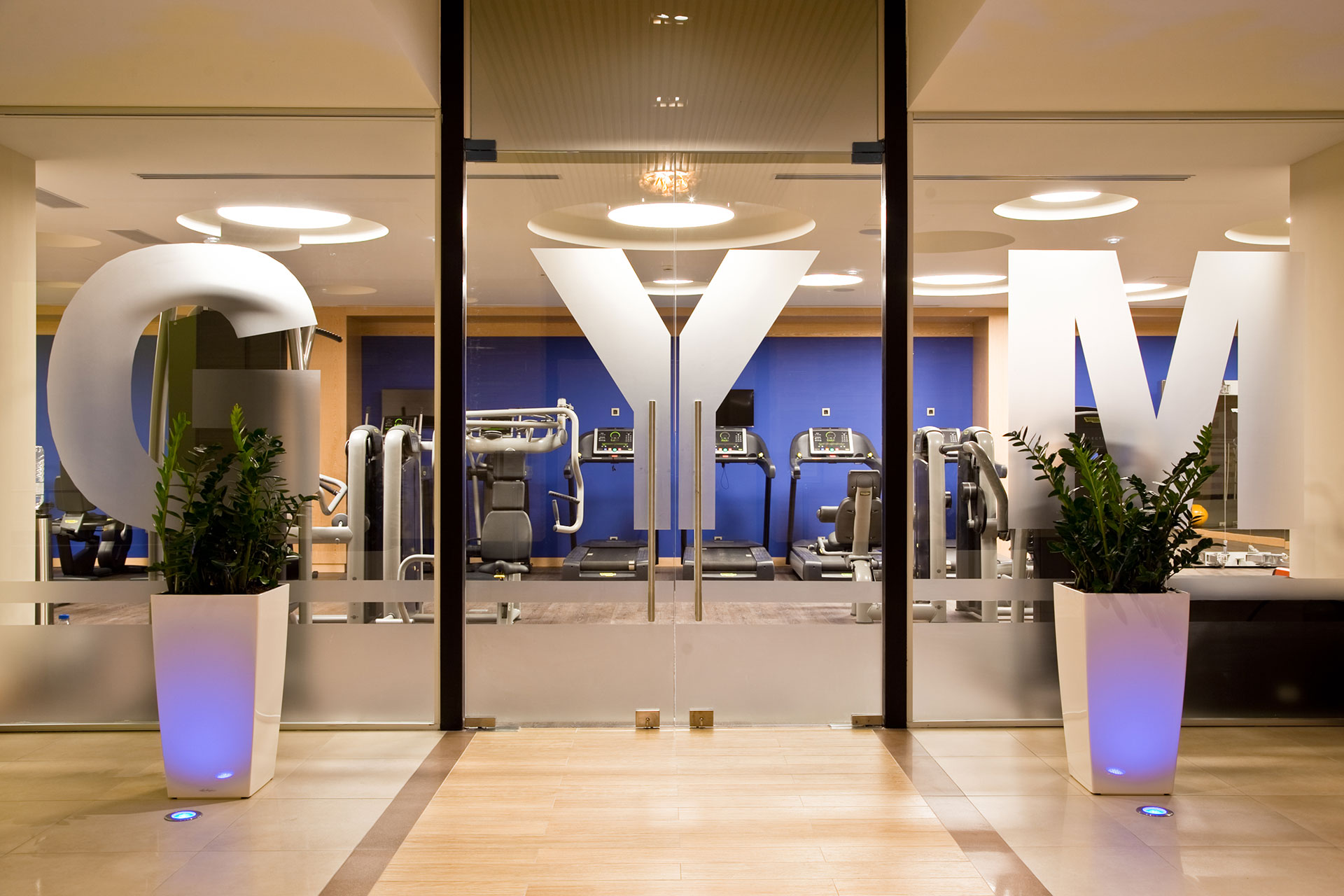 Glass entrance of the gym revealing modern fitness equipment inside