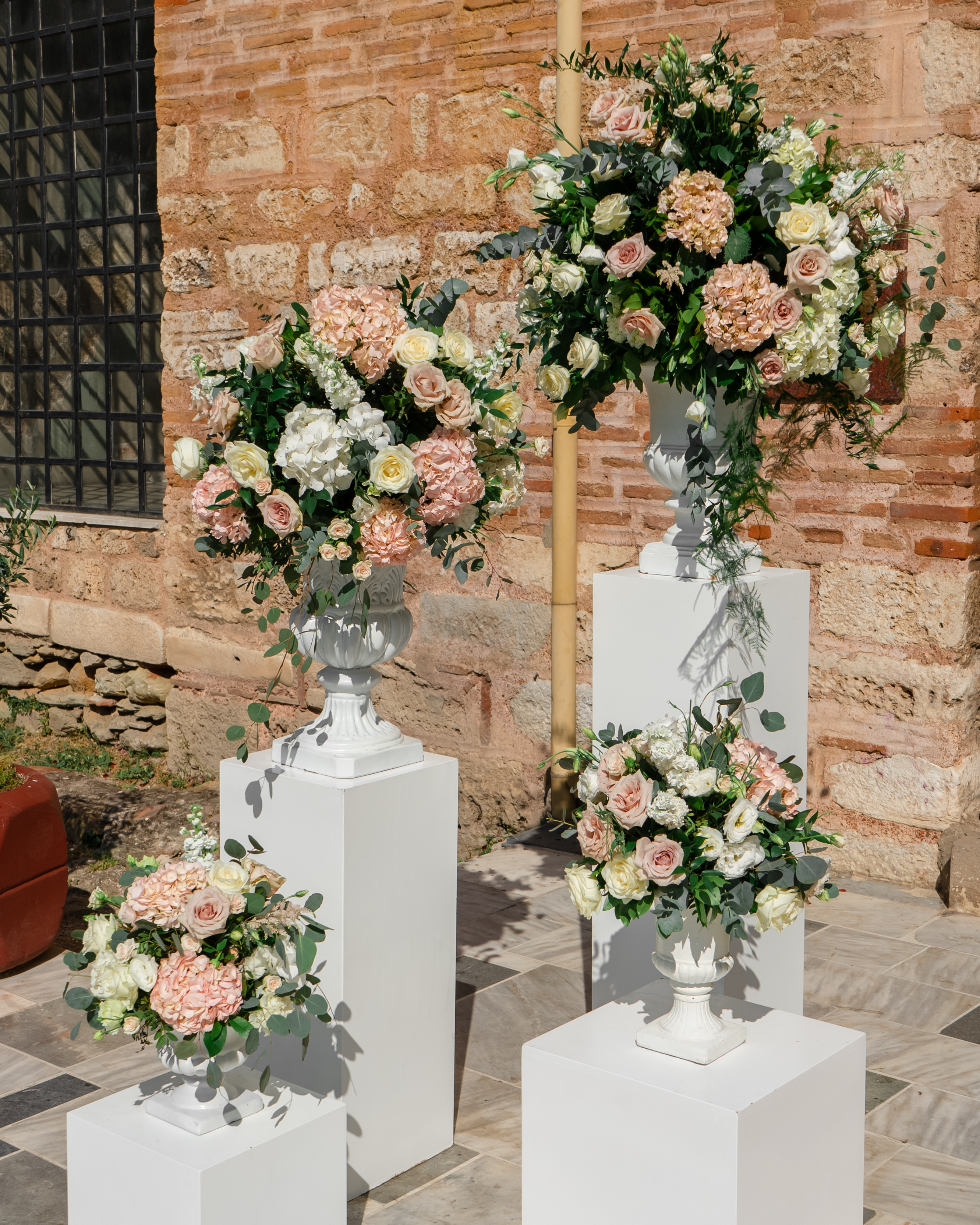 Outdoor floral decoration with pastel roses and colorful flowers in elegant vases