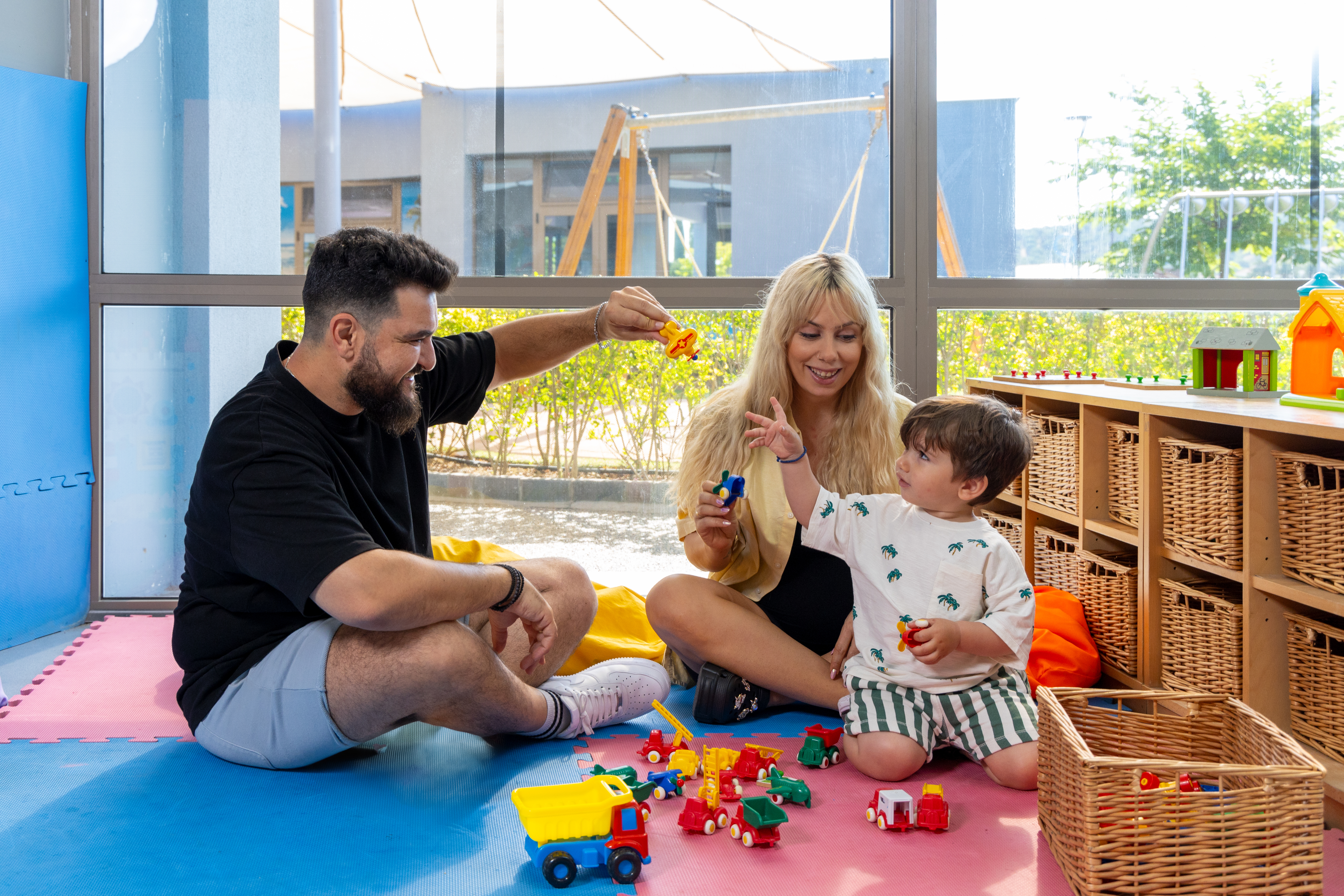 Parents playing with their child in the indoor playground of Kids Planet 