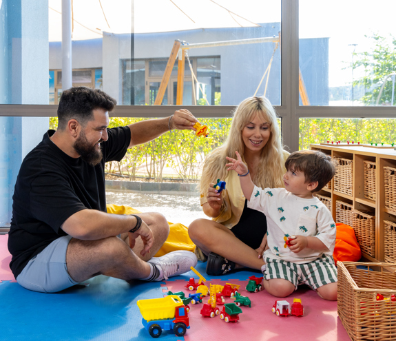 Parents playing with their child in the indoor playground of Kids Planet 
