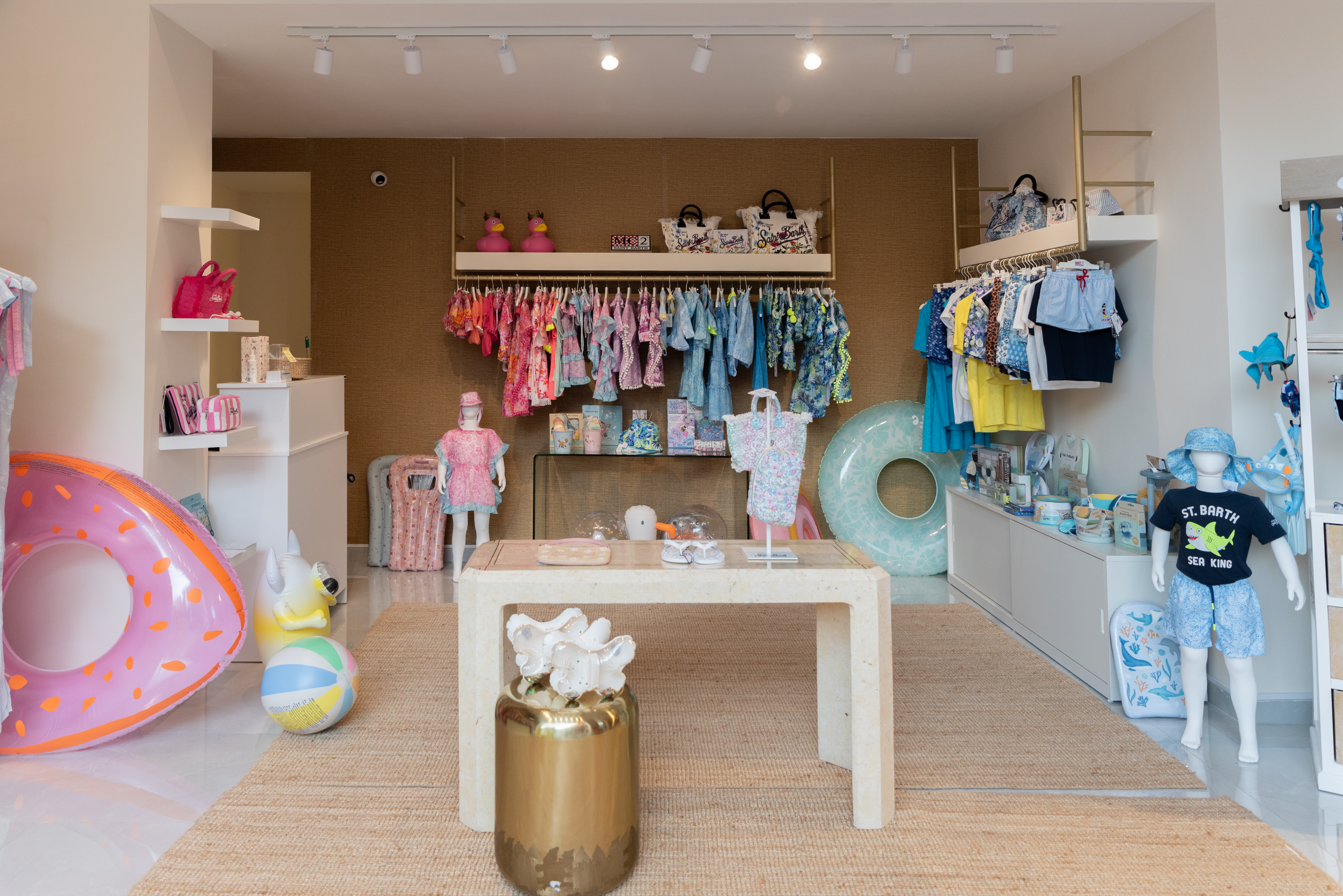 Children's boutique interior with girls' clothing on the left and boys' outfits on the right