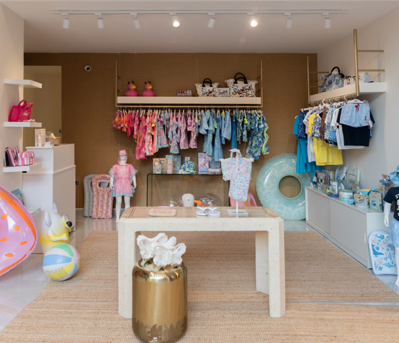 Children's boutique interior with girls' clothing on the left and boys' outfits on the right