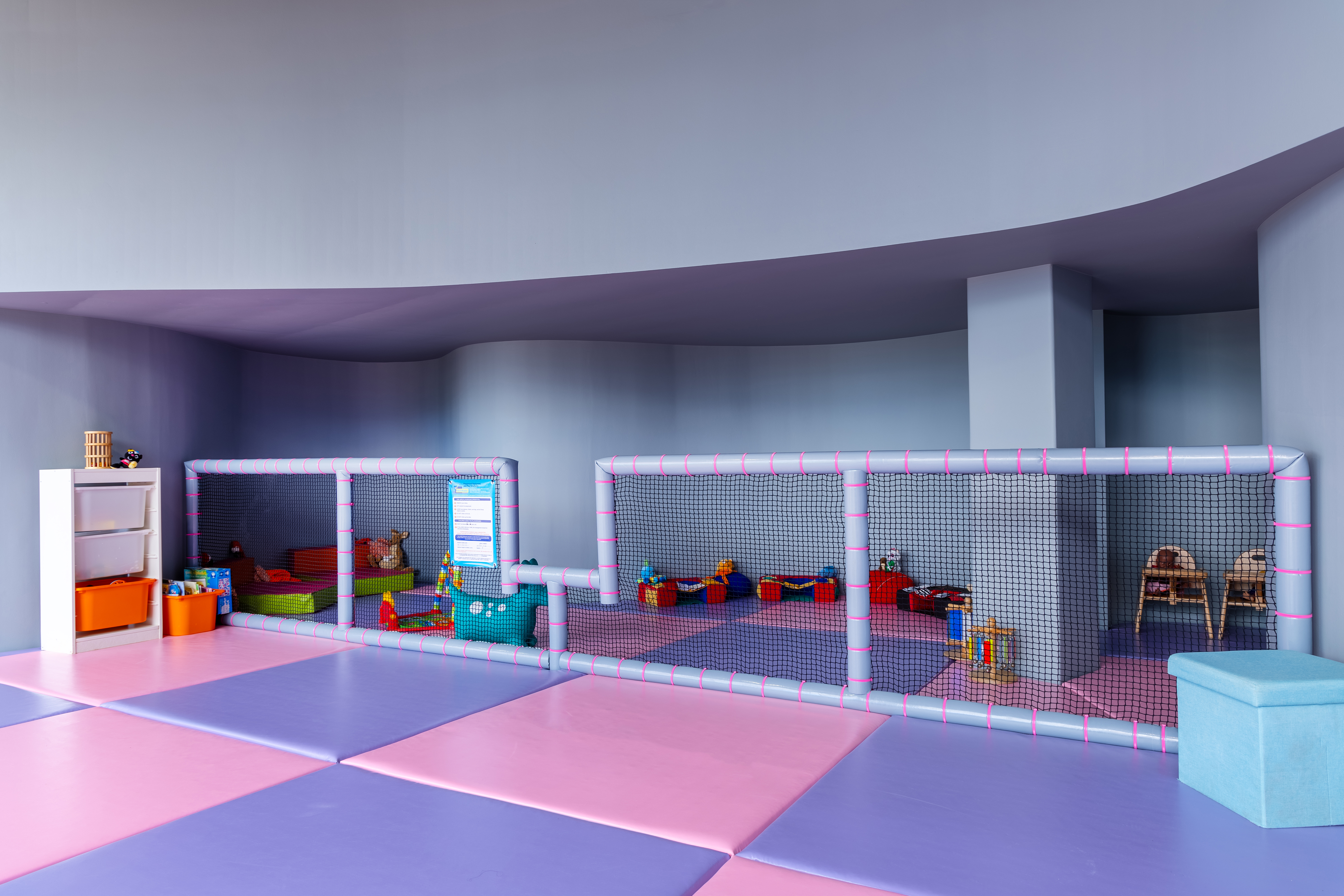Toddler play zone with soft mats, colorful toys, and safety net at Kids Planet