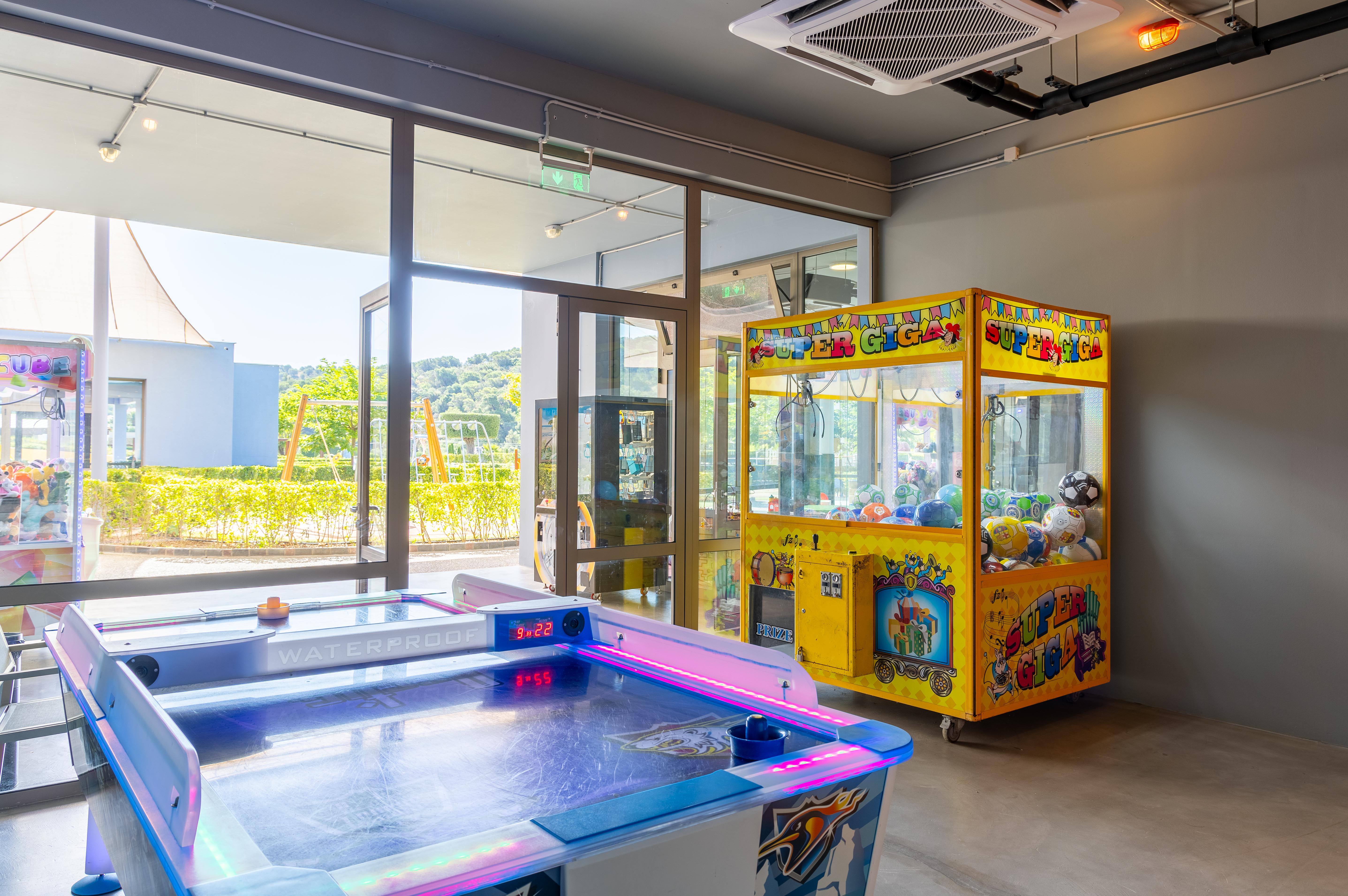 Game room with air hockey table and claw machine at Kids Planet