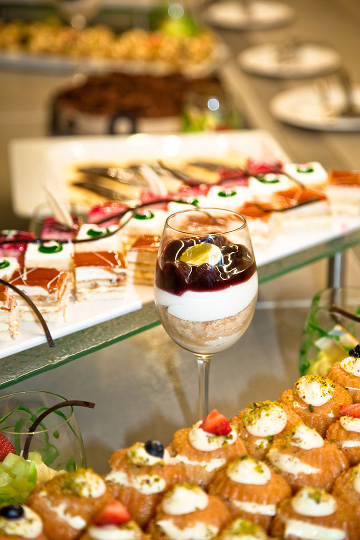 Assorted desserts and pastries with a layered cream and berry parfait at Kritamo restaurant buffet