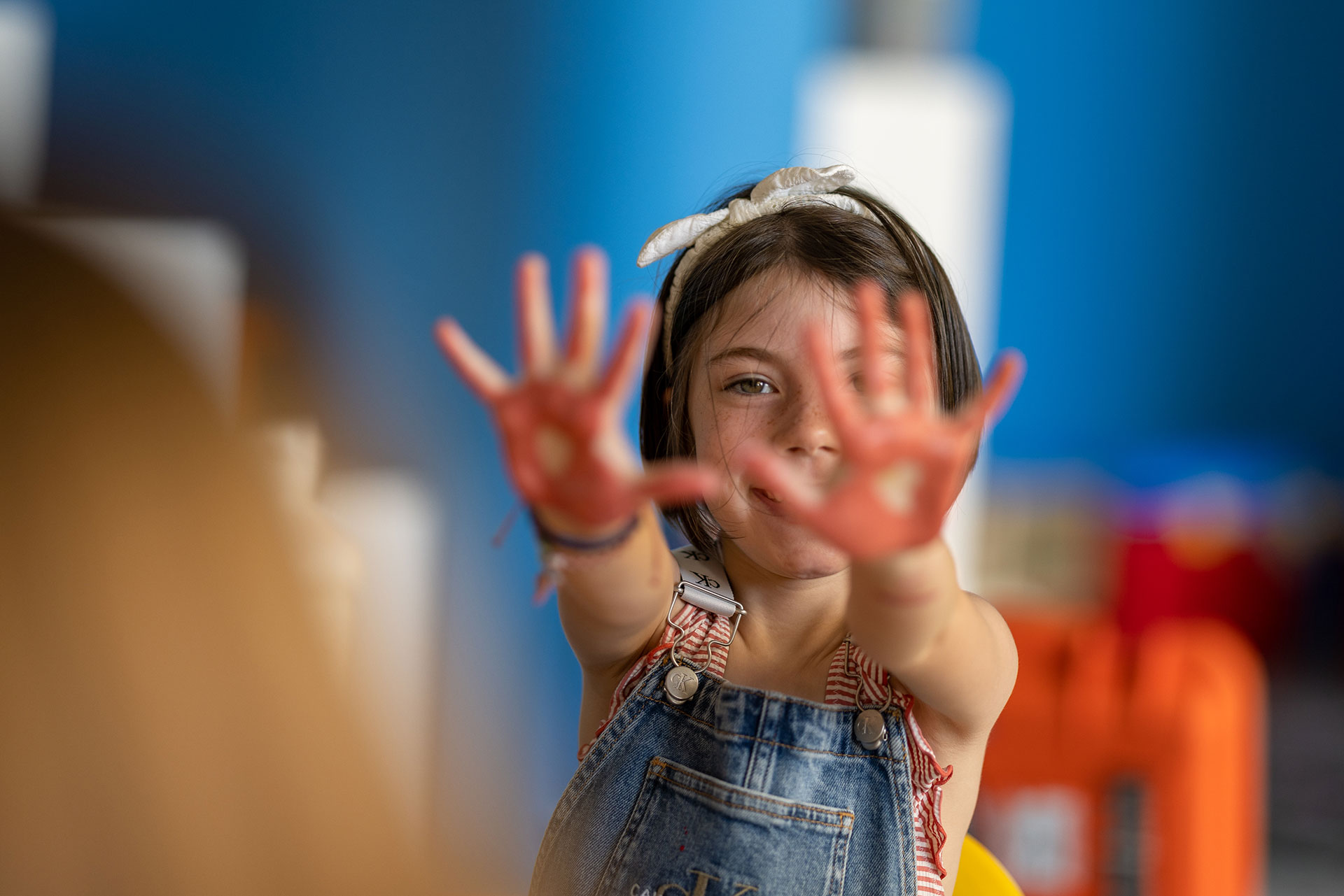 Child showing off its dyed hands in the indoor play area of Kids Planet