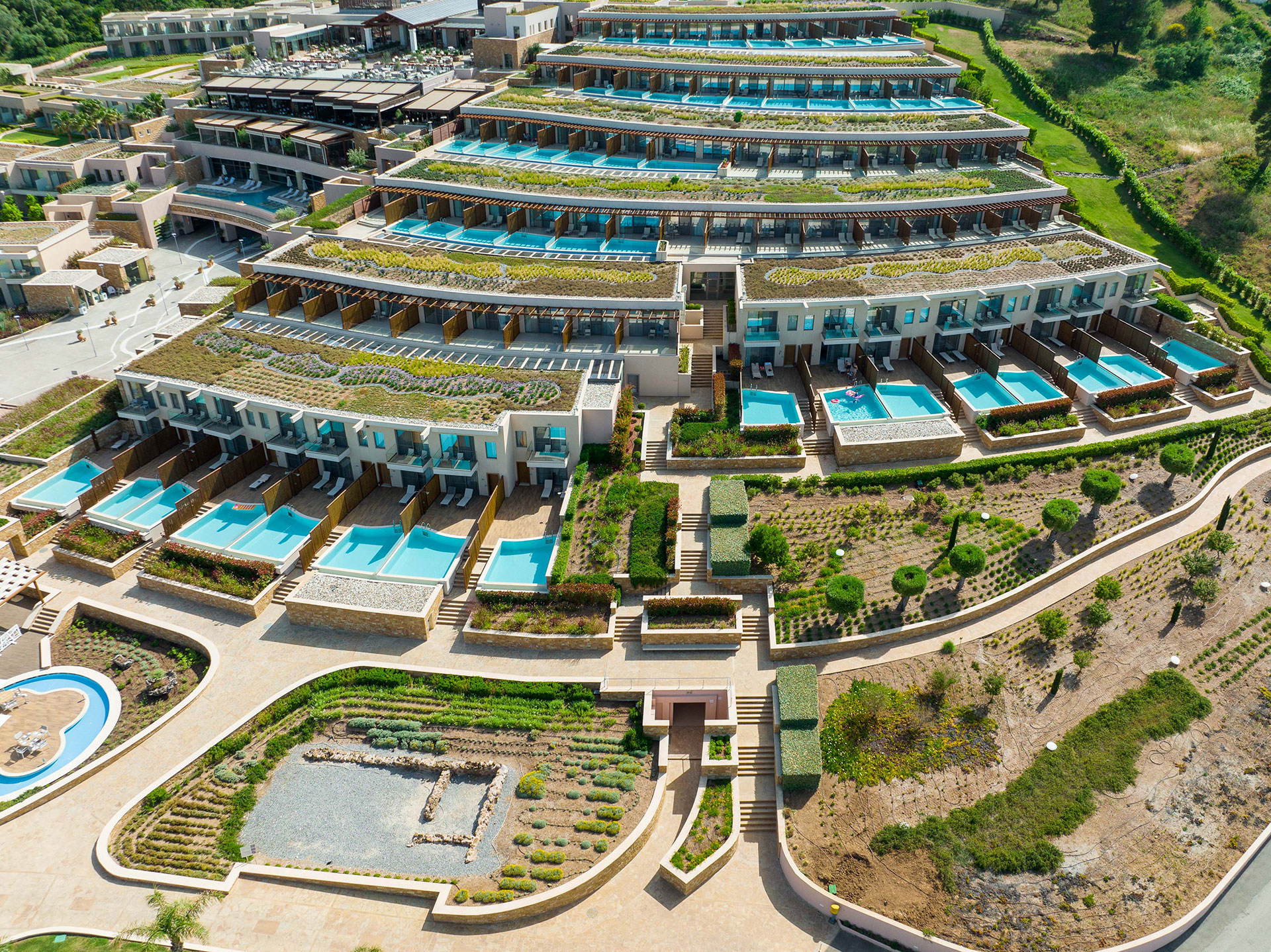 Aerial view of terraced suites with private pools and landscaped gardens