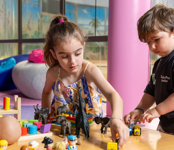 Children playing with educational toys and animal figures at the Kids Planet activity room