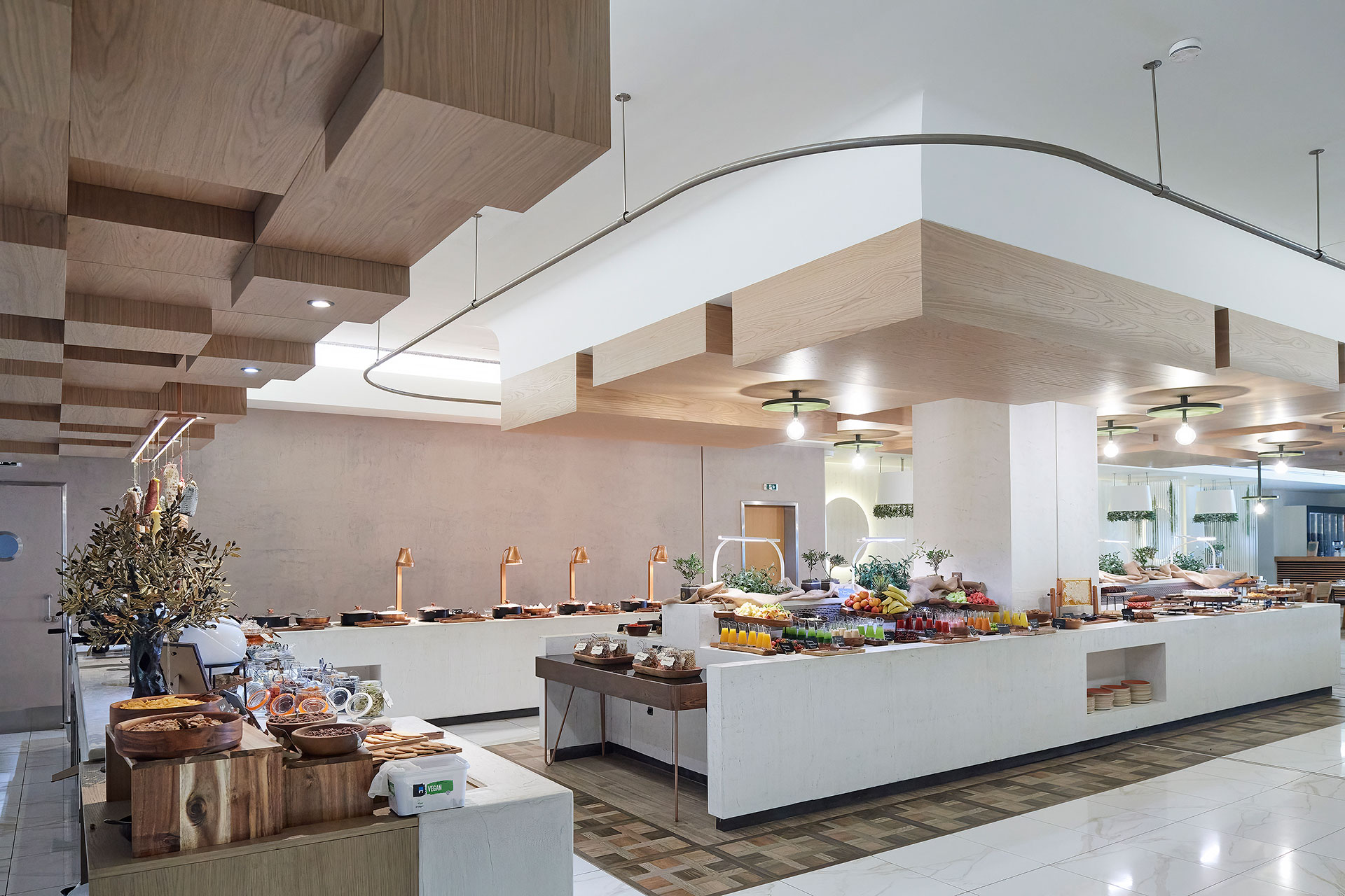 Breakfast buffet at Elia restaurant with a rich selection of fruits, pastries and fresh juices in a modern elegant setting